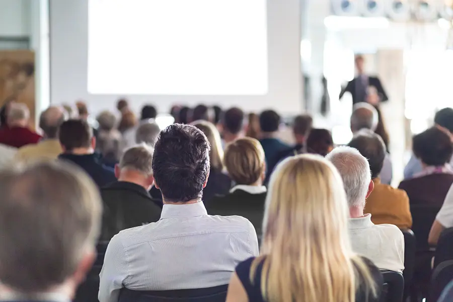 A professional audience watching a presentation, showcasing the power of AI-powered tools like hiCreo for creating stunning presentations quickly and efficiently.