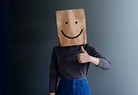 Shy person wearing a paper bag with a smiley face, representing overcoming public speaking anxiety and gaining confidence