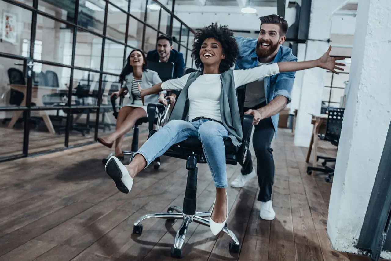 Colleagues enjoying a fun team-building moment in the office, showcasing creativity and collaboration while using an AI presentation maker to create presentations with AI.