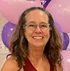 Smiling woman with glasses in front of pink and purple balloons, representing Cathy Alexander, Senior Accountant/Controller